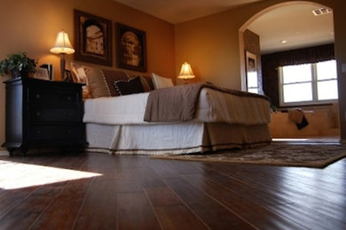 Ejemplo de dormitorio principal grande con paredes marrones y suelo de madera oscura