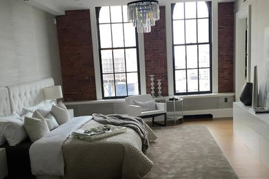 Example of a master light wood floor bedroom design in New York with white walls