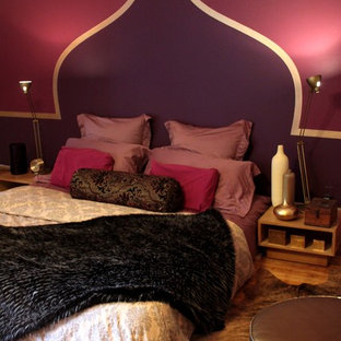 Foto de dormitorio principal, ecléctico, de tamaño medio, con paredes púrpuras y suelo de madera en tonos medios