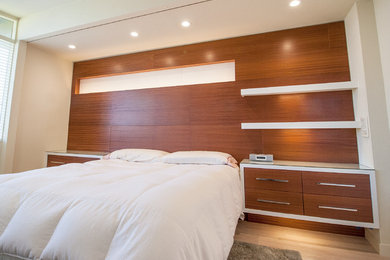 Imagen de dormitorio principal minimalista de tamaño medio sin chimenea con paredes blancas, suelo de madera clara y suelo beige