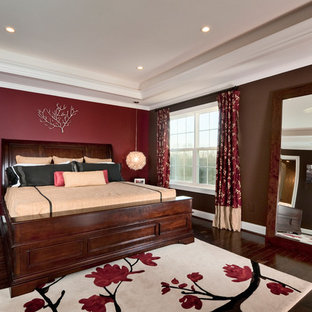 Modelo de dormitorio principal, clásico, de tamaño medio, con paredes rojas y suelo de madera oscura