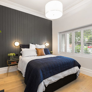 Photo of a mid-sized contemporary master bedroom in Melbourne with grey walls, light hardwood floors, a standard fireplace and a metal fireplace surround.