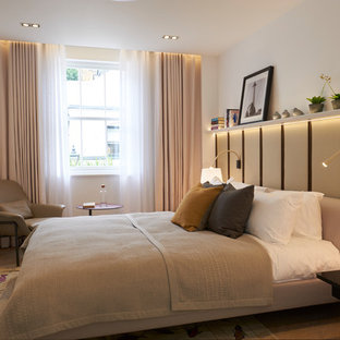 Design ideas for a contemporary bedroom in London with white walls, light hardwood flooring and no fireplace.
