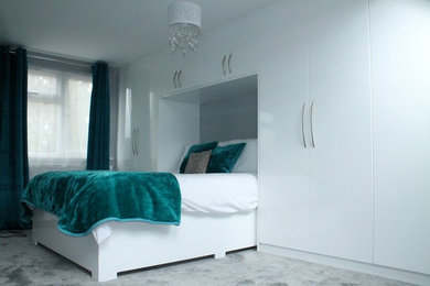 Photo of a medium sized modern guest bedroom in London with grey walls, carpet and no fireplace.