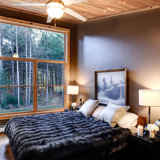 Inspiration pour une chambre parentale chalet de taille moyenne avec un sol en bambou, aucune cheminée, un sol marron et un mur gris.
