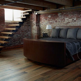 Imagen de habitación de invitados moderna, grande, con paredes rojas, suelo de madera en tonos medios y suelo marrón