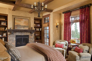 Inspiration for a mid-sized rustic master medium tone wood floor and brown floor bedroom remodel in Other with beige walls, a standard fireplace and a stone fireplace