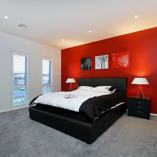 Réalisation d'une grand chambre design avec un mur rouge et un sol gris.