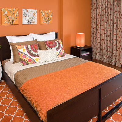 Inspiration for a mid-sized eclectic guest orange floor and medium tone wood floor bedroom remodel in San Francisco with orange walls and no fireplace