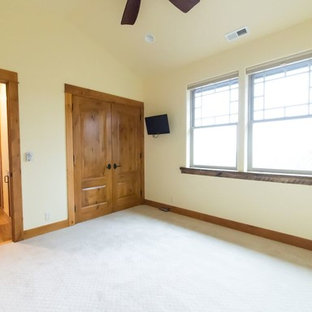 Imagen de habitación de invitados rústica, de tamaño medio, sin chimenea, con paredes beige y suelo de travertino