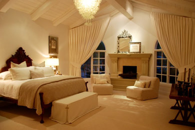 Ejemplo de dormitorio principal tradicional renovado grande con paredes grises, moqueta, todas las chimeneas y marco de chimenea de piedra
