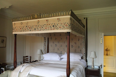 グロスタシャーにある広いトラディショナルスタイルのおしゃれな客用寝室 (白い壁、カーペット敷き、標準型暖炉、木材の暖炉まわり) のレイアウト