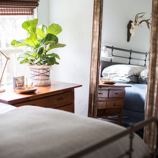 Imagen de dormitorio principal, bohemio, de tamaño medio, sin chimenea, con paredes azules, suelo de bambú y suelo marrón