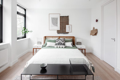 Inspiration for a scandi bedroom in London with white walls, light hardwood flooring and beige floors.