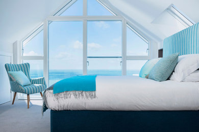 На фото: хозяйская спальня в морском стиле с белыми стенами и ковровым покрытием с