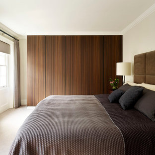 Inspiration for a large contemporary master bedroom in London with beige walls and carpet.