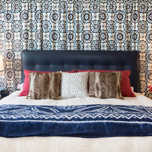 Ejemplo de dormitorio principal, contemporáneo, de tamaño medio, con paredes azules, suelo de madera clara, chimenea de doble cara y marco de chimenea de baldosas y/o azulejos