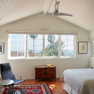 Design ideas for a mediterranean bedroom in Los Angeles with white walls, medium hardwood floors, brown floor and timber.
