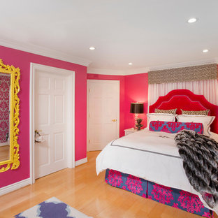 Modelo de dormitorio principal, bohemio, de tamaño medio, con paredes rosas y suelo de madera clara