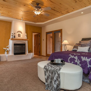 Foto de dormitorio principal, de estilo americano, grande, con paredes amarillas, moqueta, chimenea tradicional y marco de chimenea de yeso