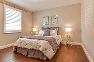Inspiration for a transitional guest medium tone wood floor bedroom remodel in Toronto with beige walls