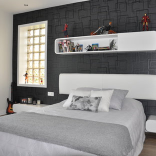 Modelo de dormitorio tipo loft, minimalista, de tamaño medio, con paredes negras y suelo de madera en tonos medios