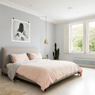 Modelo de dormitorio contemporáneo con paredes grises y suelo de madera clara