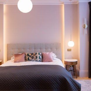 Exemple d'une chambre parentale tendance de taille moyenne avec un mur rose, un sol en bois clair et un sol beige.
