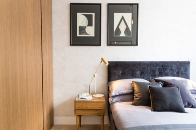 Esempio di una camera da letto contemporanea di medie dimensioni con pareti bianche, parquet chiaro e pavimento beige