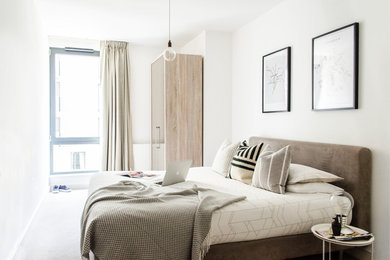 Modelo de dormitorio principal escandinavo de tamaño medio sin chimenea con paredes blancas y moqueta