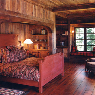 Foto de dormitorio principal, rural, de tamaño medio, con paredes marrones y suelo de madera oscura