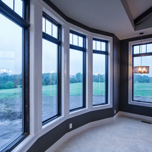 Diseño de dormitorio principal, tradicional renovado, grande, con paredes grises, moqueta, chimeneas suspendidas y marco de chimenea de piedra