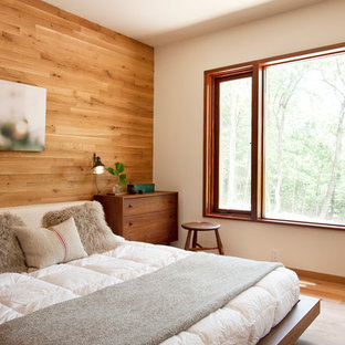 Imagen de dormitorio principal, actual, de tamaño medio, con suelo de madera en tonos medios y paredes blancas