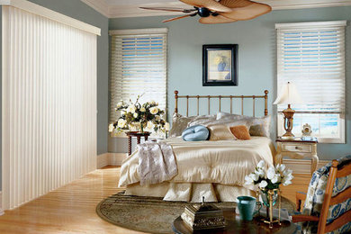 Diseño de dormitorio principal marinero de tamaño medio sin chimenea con paredes azules, suelo de madera clara y suelo marrón