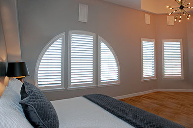 フェニックスにある中くらいなトランジショナルスタイルのおしゃれな主寝室 (グレーの壁、無垢フローリング、暖炉なし、茶色い床) のインテリア