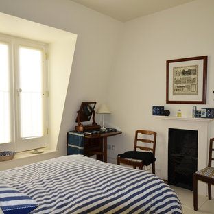 Foto de dormitorio tipo loft, actual, grande, con paredes blancas, suelo de madera pintada, chimenea tradicional y marco de chimenea de yeso