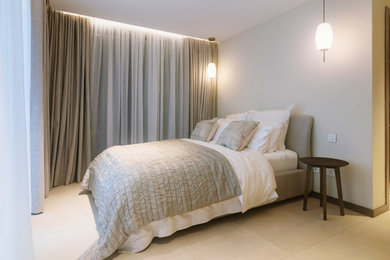 Modelo de habitación de invitados contemporánea pequeña sin chimenea con paredes beige, suelo de baldosas de cerámica y suelo beige