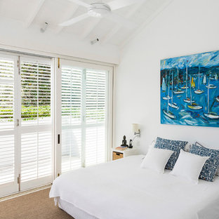 Inspiration for a beach style guest bedroom in Sydney with white walls, carpet and beige floor.