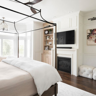 Imagen de dormitorio principal y boiserie, clásico, boiserie, con suelo de madera oscura, chimenea tradicional, marco de chimenea de hormigón y boiserie