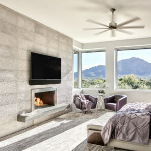 Foto de dormitorio principal, minimalista, extra grande, con paredes blancas, moqueta, chimenea de doble cara, marco de chimenea de metal y suelo gris