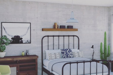 オークランドにある中くらいなインダストリアルスタイルのおしゃれな客用寝室 (グレーの壁、コンクリートの床、白い床) のインテリア