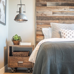 Modelo de dormitorio principal, rústico, de tamaño medio, con paredes beige y suelo de madera en tonos medios