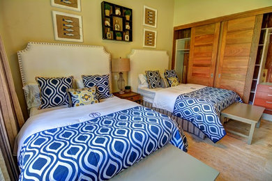 他の地域にある広いトロピカルスタイルのおしゃれな客用寝室 (緑の壁、トラバーチンの床) のインテリア