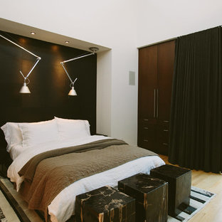 Imagen de dormitorio tipo loft, contemporáneo, con paredes negras y suelo de madera clara
