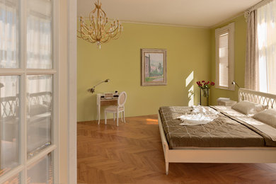 Пример оригинального дизайна: хозяйская спальня среднего размера в современном стиле с желтыми стенами и деревянным полом без камина