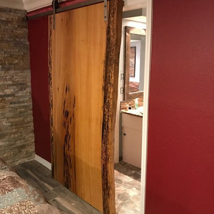 Imagen de dormitorio principal, rural, de tamaño medio, con paredes rojas, suelo de pizarra y suelo gris