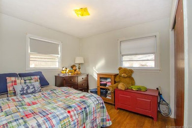Diseño de dormitorio clásico de tamaño medio sin chimenea con paredes beige, suelo de madera en tonos medios y suelo marrón