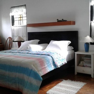 Ejemplo de dormitorio principal, clásico, grande, sin chimenea, con paredes blancas, suelo de contrachapado y suelo marrón
