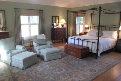 Foto de dormitorio principal tradicional de tamaño medio sin chimenea con paredes verdes y suelo de madera clara