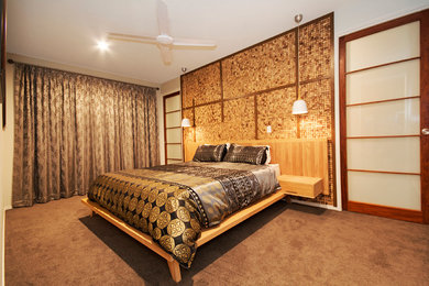 サンシャインコーストにある広いアジアンスタイルのおしゃれな主寝室 (緑の壁、カーペット敷き)